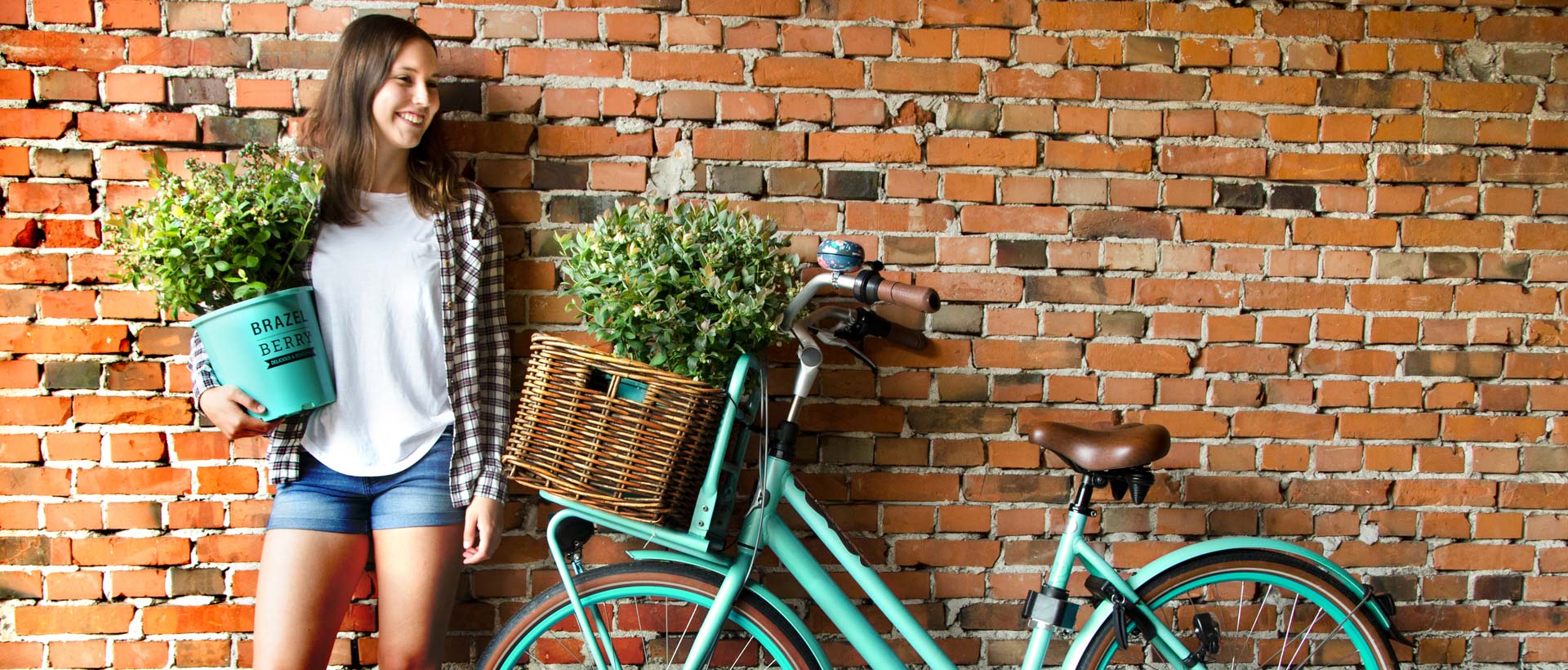 Junge Frau mit Fahrrad und BrazelBerry® auf dem Arm